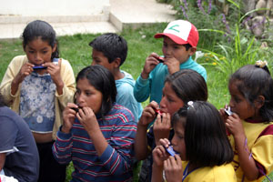 Les enfants s'essayent a l'harmonica pour preparer le Corso des Enfants pour le Carnaval